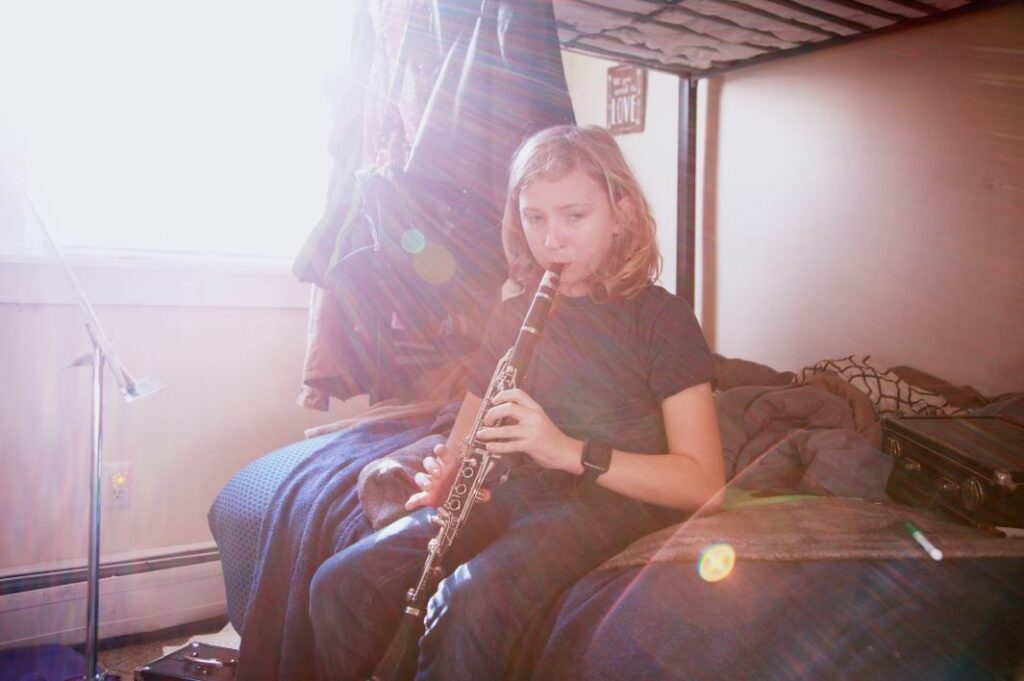 fille qui apprend la clarinette dans sa chambre
