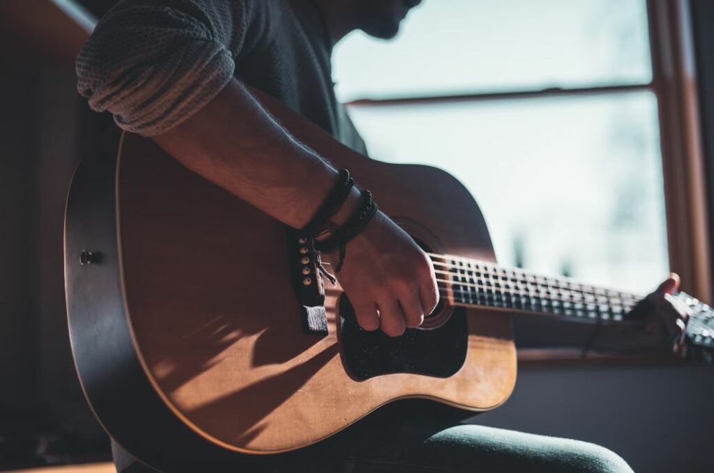 homme prenant des cours de guitare